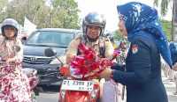 Salah satu pegawai KPU Sulawesi Tenggara saat memberikan bunga kepada pengendara motor yang melintas di traffic light MTQ, Jalan Abdullah Silondae, Kota Kendari pada Selasa (14/2/2023) pagi/Ist